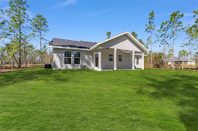 791 NE 150th Ave, Williston, FL 32696 - back of house with stucco siding, a yard, and ceiling fan