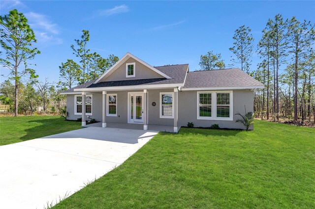791 NE 150th Ave, Williston, FL 32696 - view of front of house with a shingled roof, a front lawn, driveway, and stucco siding