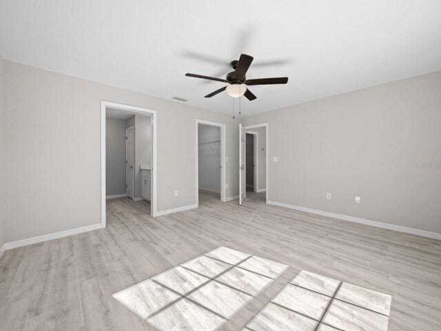 3 Pine Court Ln, Ocala, FL 34472 - unfurnished bedroom with a closet, baseboards, a walk in closet, and light wood-style floors
