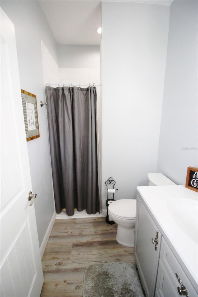 full bathroom featuring toilet, wood finished floors, curtained shower, vanity, and recessed lighting