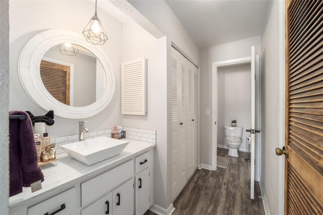 3870 NE 17th Street Cir, Ocala, FL 34470 - bathroom featuring vanity, toilet, baseboards, a closet, and wood finished floors
