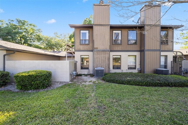 3870 NE 17th Street Cir, Ocala, FL 34470 - rear view of house with central AC, a yard, and a chimney