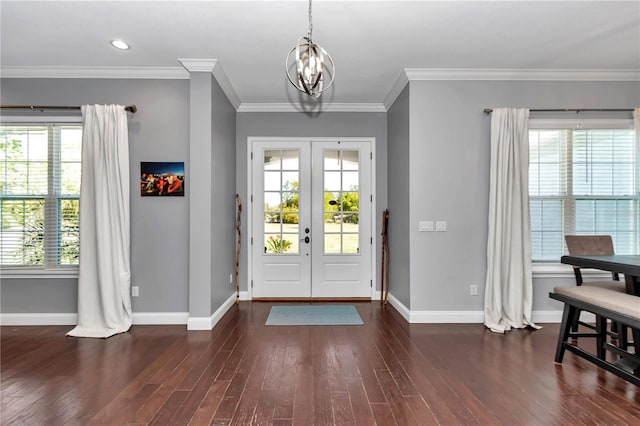 foyer featuring an inviting chandelier, dark wood-type flooring, and a healthy amount of sunlight
