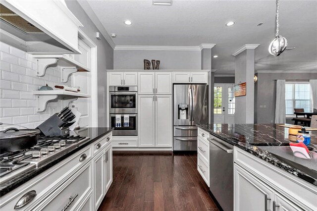 kitchen with white cabinets, wall chimney exhaust hood, stainless steel appliances, dark stone countertops, and dark wood-style floors