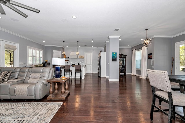 living area featuring dark wood-style floors, a healthy amount of sunlight, ceiling fan, and baseboards