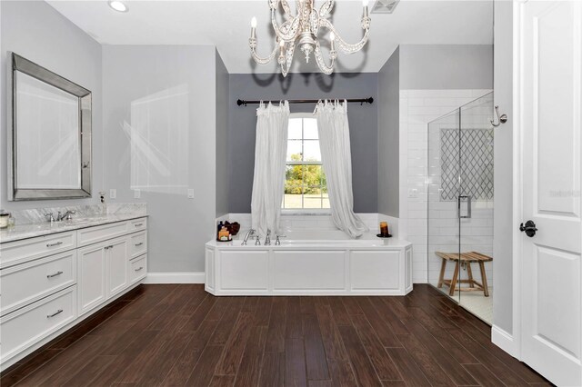 full bathroom featuring wood finished floors, a garden tub, a notable chandelier, and a shower stall