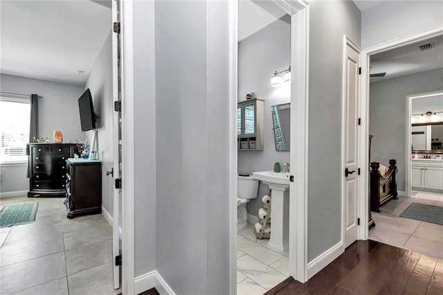 corridor with baseboards and visible vents