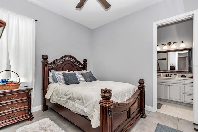 bedroom featuring a sink, ceiling fan, baseboards, and ensuite bathroom