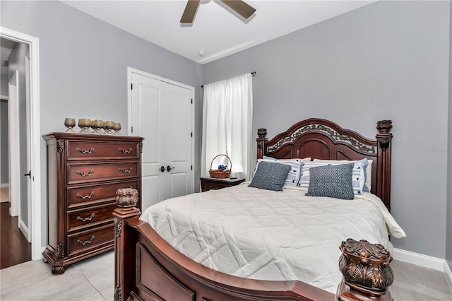 bedroom with baseboards, a closet, light tile patterned floors, and a ceiling fan