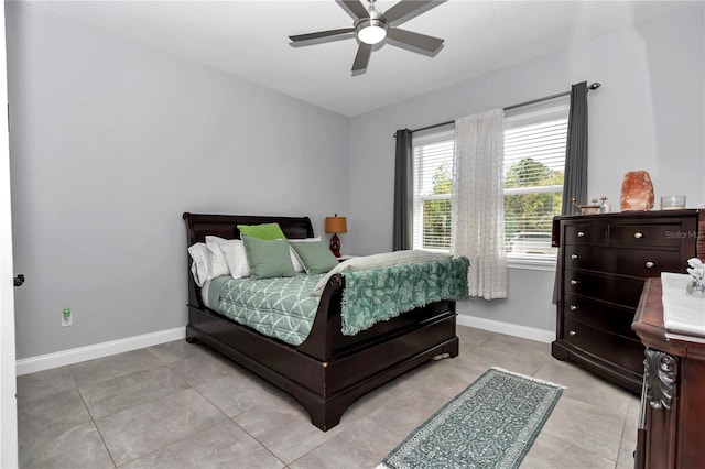 bedroom with a ceiling fan, light tile patterned floors, and baseboards