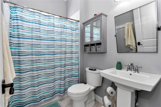 bathroom with a shower with shower curtain, baseboards, toilet, a sink, and tile patterned flooring