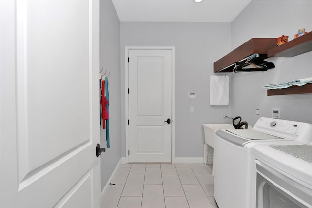 laundry room with independent washer and dryer, light tile patterned floors, baseboards, and laundry area