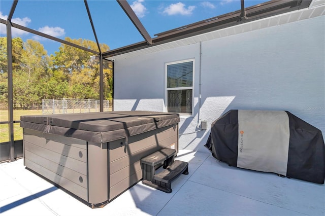 view of patio / terrace with glass enclosure, a grill, and a hot tub