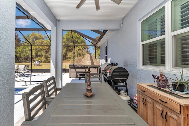 view of patio / terrace with glass enclosure, ceiling fan, and outdoor dining area