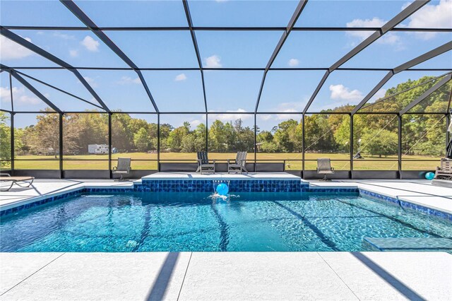 outdoor pool featuring glass enclosure and a patio