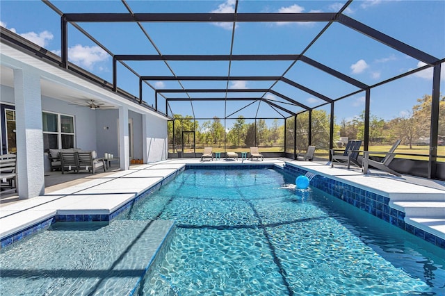 pool featuring glass enclosure, ceiling fan, and a patio
