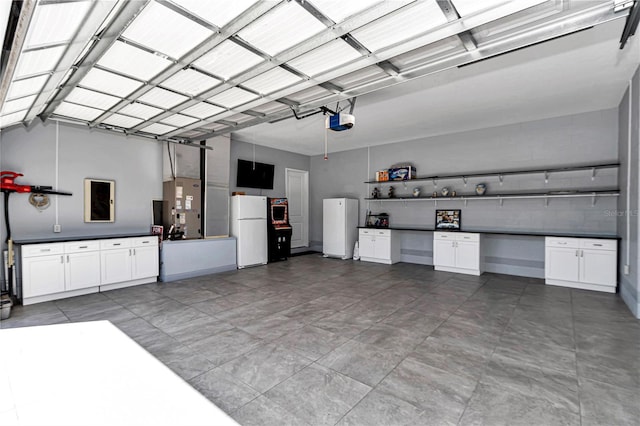 garage with a garage door opener and freestanding refrigerator