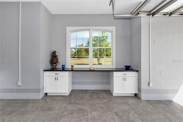 interior space featuring white cabinets and dark countertops