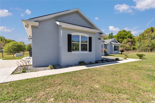 view of front facade with a front yard and stucco siding