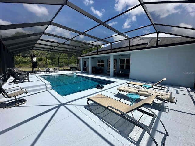 outdoor pool with a ceiling fan, a lanai, and a patio area