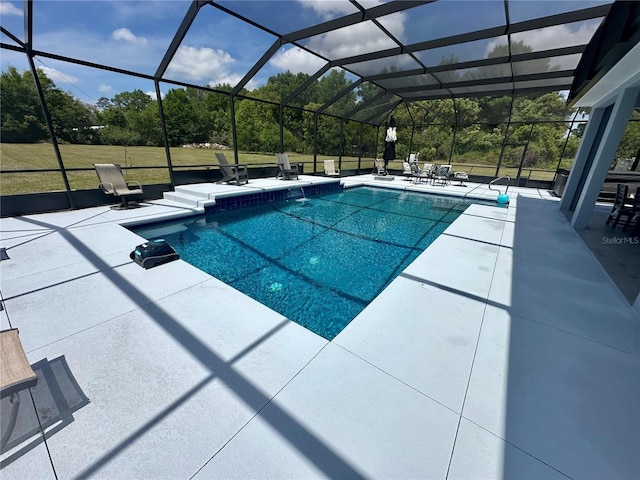 outdoor pool with glass enclosure and a patio area
