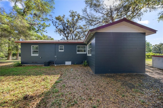 rear view of property with a yard, metal roof, and crawl space