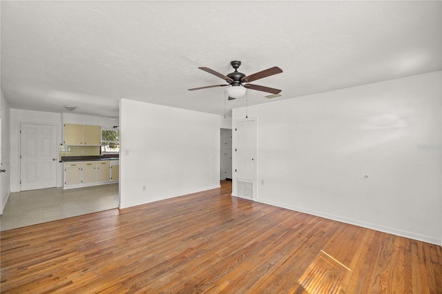 unfurnished living room featuring light wood-type flooring and ceiling fan