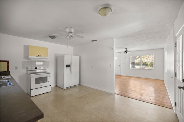 kitchen with light floors, white appliances, and a ceiling fan