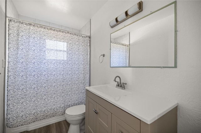 bathroom featuring vanity, a shower with curtain, toilet, and wood finished floors