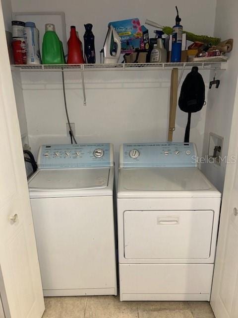 laundry area featuring light tile patterned floors, laundry area, and washer and dryer
