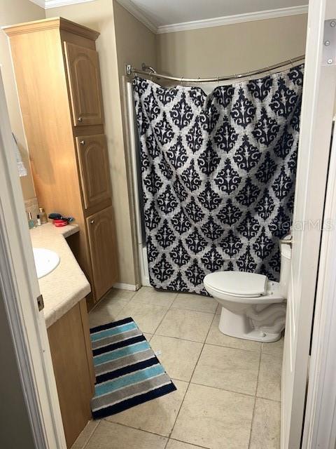 bathroom with tile patterned floors, vanity, toilet, ornamental molding, and a shower with shower curtain