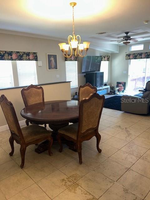 dining area with ornamental molding, ceiling fan with notable chandelier, light tile patterned floors, and a healthy amount of sunlight