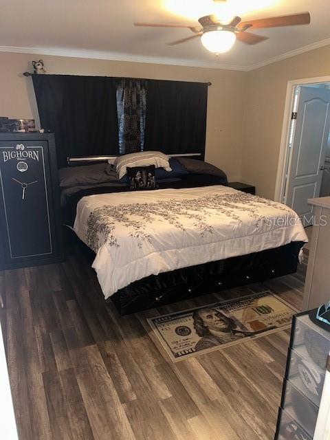 bedroom featuring crown molding, ceiling fan, and dark wood-style floors