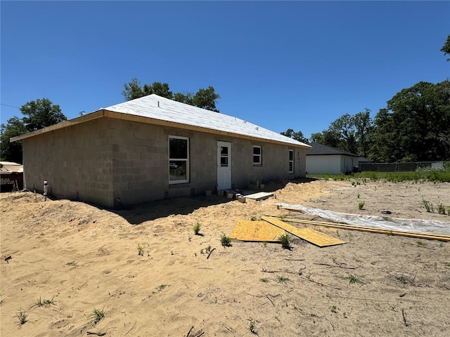 back of house with concrete block siding