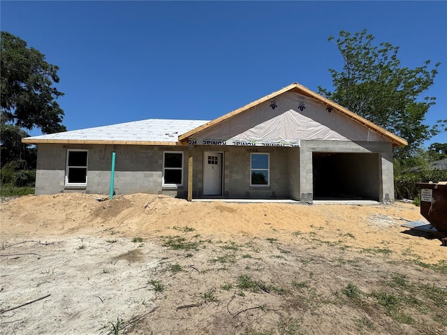 view of front facade with concrete block siding and an attached garage