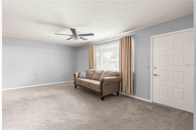 sitting room featuring carpet, a textured ceiling, a ceiling fan, and baseboards