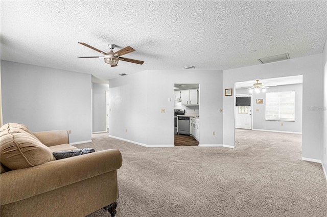 living room with ceiling fan, baseboards, carpet flooring, and a textured ceiling
