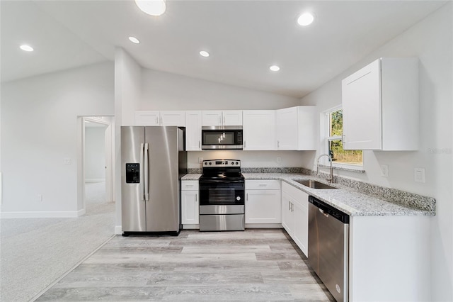 15954 SW 30th Ln, Ocala, FL 34481 - kitchen featuring light stone countertops, stainless steel appliances, white cabinetry, a sink, and vaulted ceiling