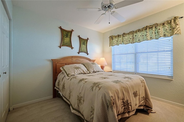 bedroom featuring baseboards, light carpet, and ceiling fan