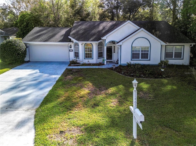 ranch-style house with stucco siding, a front lawn, a garage, and driveway