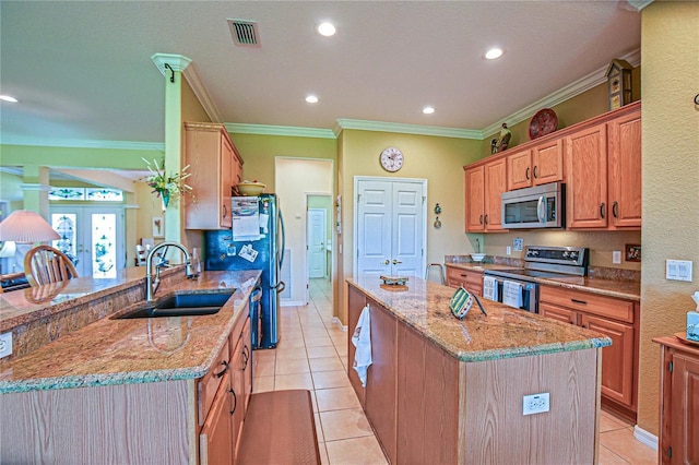 13968 SE 96th Cir, Summerfield, FL 34491 - kitchen featuring stainless steel appliances, a sink, a center island with sink, light stone counters, and ornamental molding