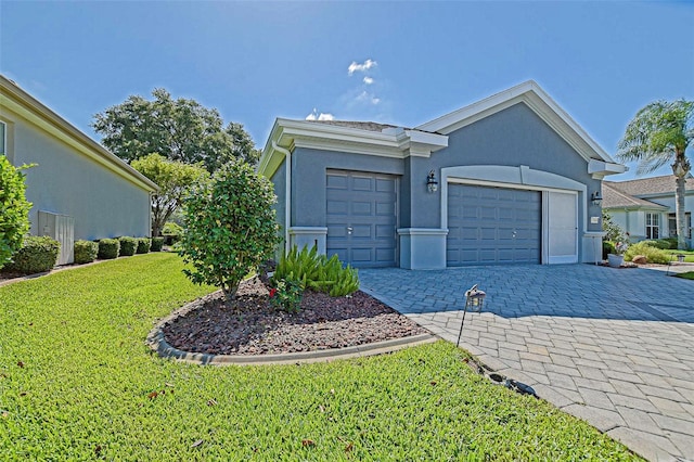 13968 SE 96th Cir, Summerfield, FL 34491 - ranch-style home featuring a front lawn, decorative driveway, an attached garage, and stucco siding