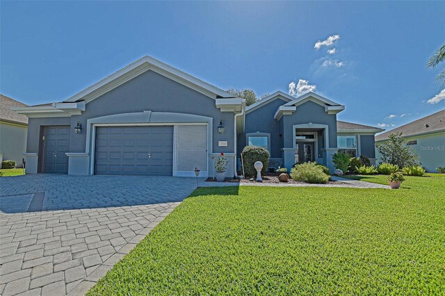 13968 SE 96th Cir, Summerfield, FL 34491 - ranch-style home featuring stucco siding, a front lawn, decorative driveway, and an attached garage