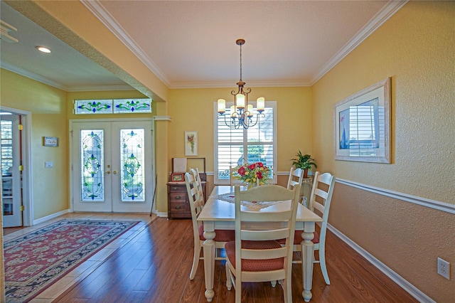 13968 SE 96th Cir, Summerfield, FL 34491 - dining space featuring french doors, wood finished floors, a chandelier, crown molding, and baseboards