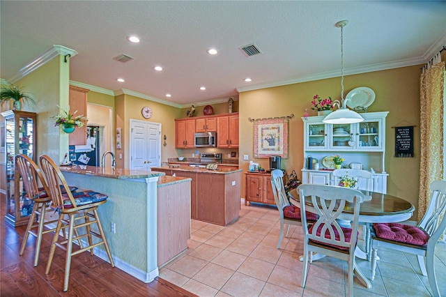 13968 SE 96th Cir, Summerfield, FL 34491 - kitchen featuring stainless steel appliances, a kitchen island, ornamental molding, a sink, and recessed lighting