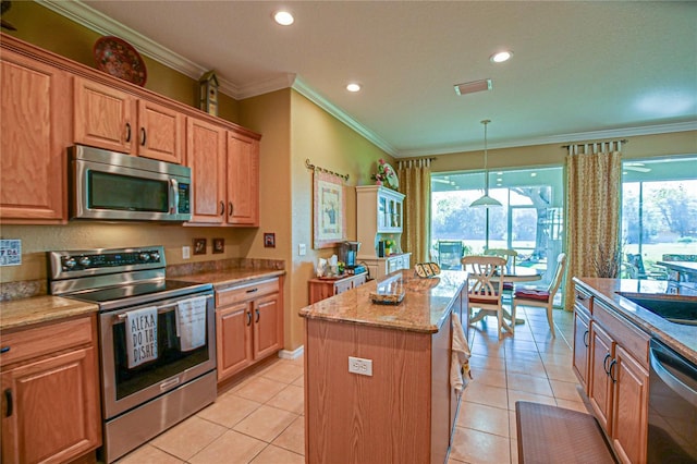 13968 SE 96th Cir, Summerfield, FL 34491 - kitchen featuring appliances with stainless steel finishes, ornamental molding, a center island, healthy amount of natural light, and light stone counters