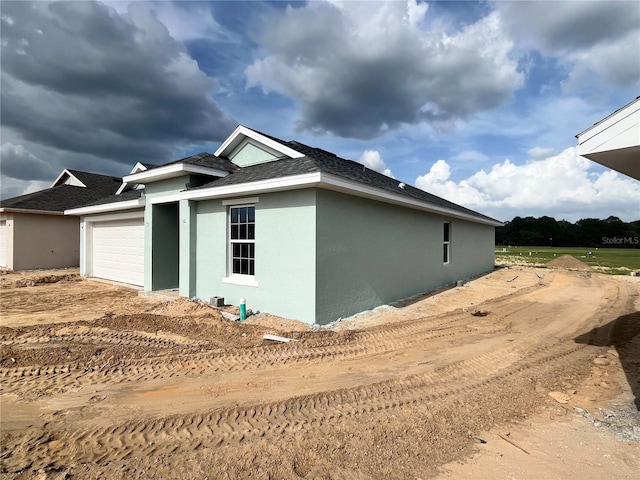 4504 SW 90th Lane Rd, Ocala, FL 34476 - view of home's exterior with an attached garage, stucco siding, and roof with shingles