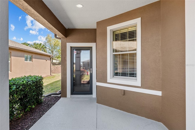 doorway to property featuring stucco siding