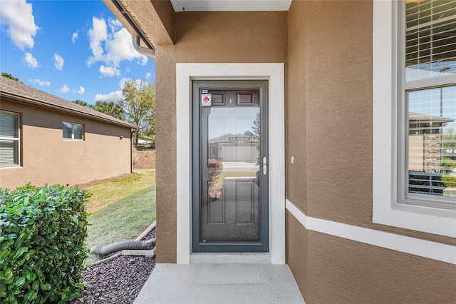 property entrance with stucco siding