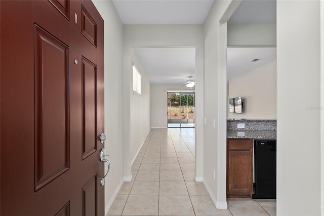 interior space with light tile patterned flooring, baseboards, and ceiling fan